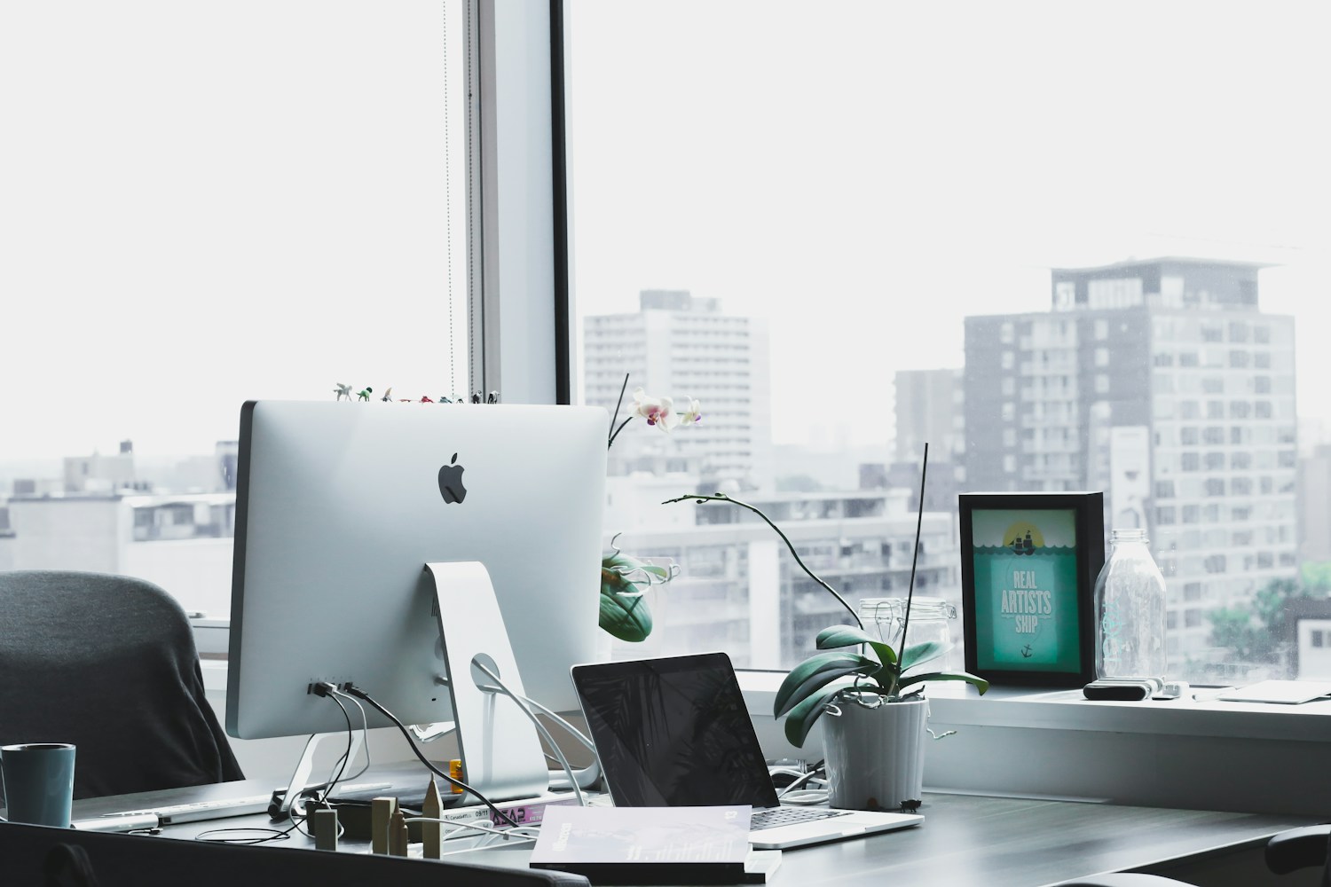 A bright workspace with desks, computers, and natural light